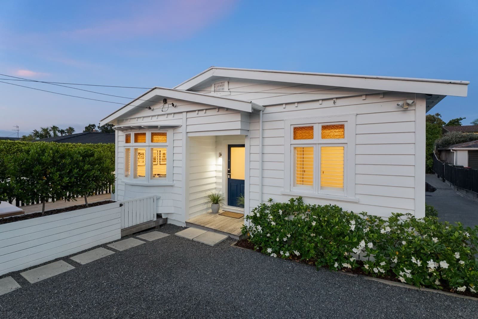 A 1920s Point Chevalier bungalow lit at dusk
