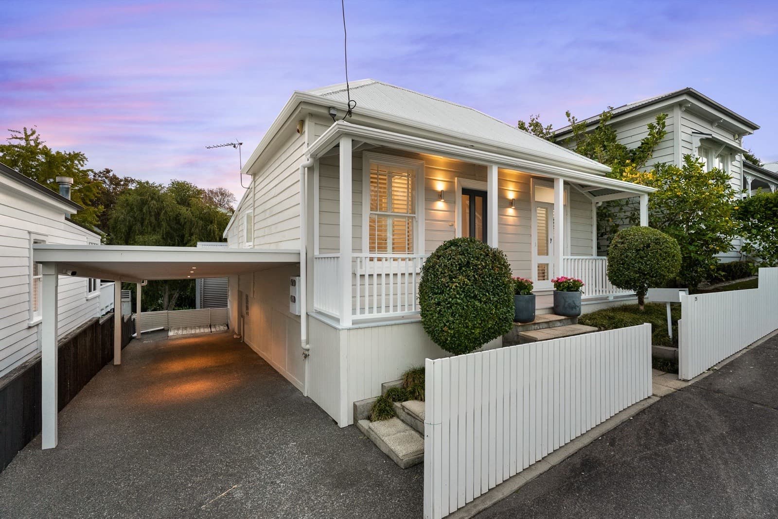 A family villa with a wide verandah on a quiet Ponsonby street at dusk