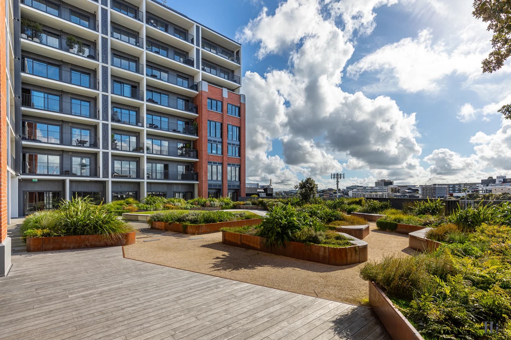 Modern Eden Terrace apartment building with rooftop garden, corten steel planters and timber deck