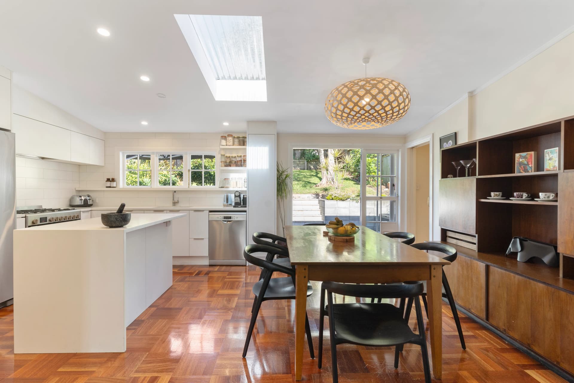 Open-plan living area in a Kingsland villa with polished timber floors, high ceilings and garden views