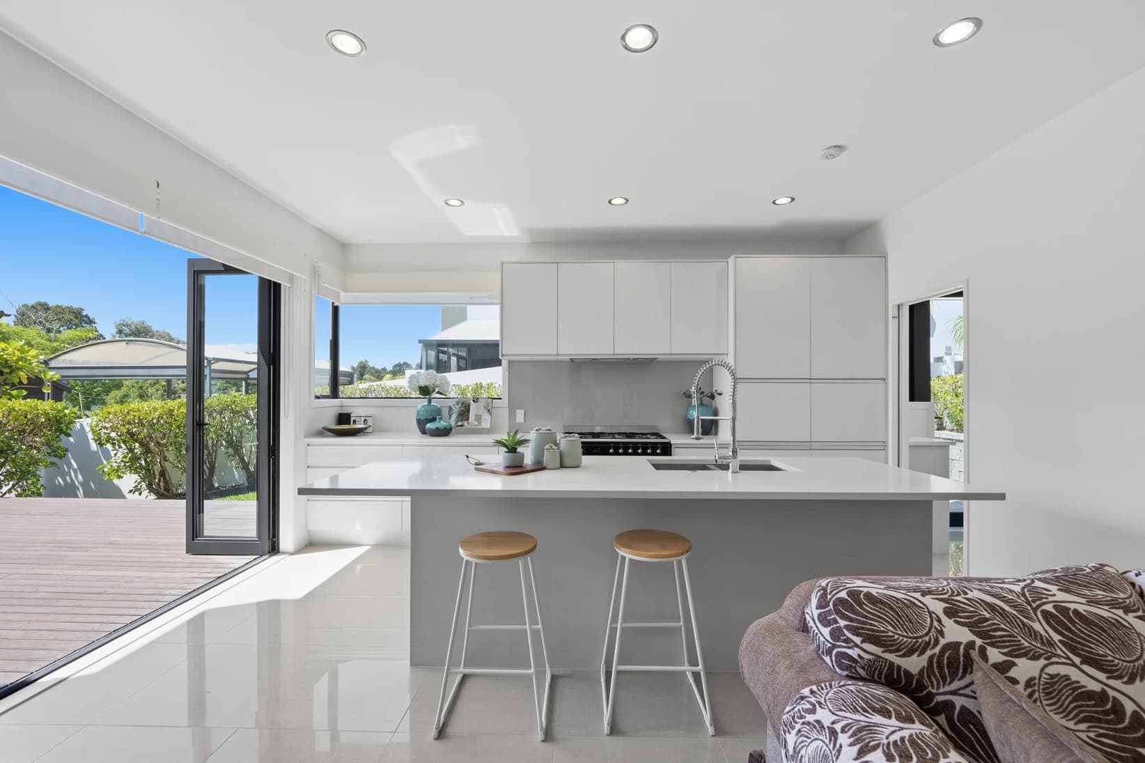 Open-plan living area in a Remuera villa with native timber floors and garden outlook through large windows